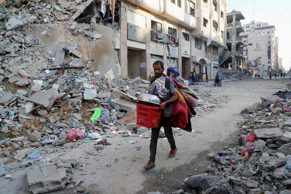 رجل فلسطيني يحمل أمتعته أثناء عملية عسكرية إسرائيلية بعد صدور أوامر إخلاء في مدينة غزة
