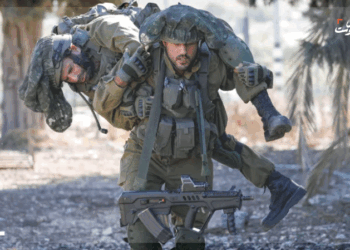 احد الجنود الاسرائيليين يحمل جندي تم اصابته في غزة