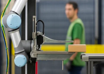 روبوت فولكان داخل أحد مستودعات أمازون يعمل بجانب موظف يرتدي سترة أمان، في مشهد يُجسد مستقبل الوظائف في عصر الروبوتات