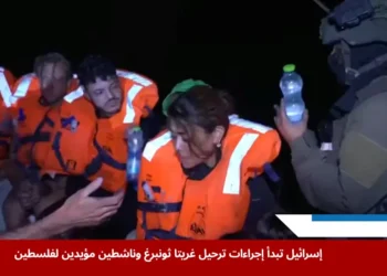 جندي إسرائيلي يقدم الماء لركاب يخت "مادلين" المتجه إلى غزة، بعد اعتراضه خلال محاولة كسر الحصار البحري، ضمن رحلة ضمت غريتا ثونبرغ. (رويترز)