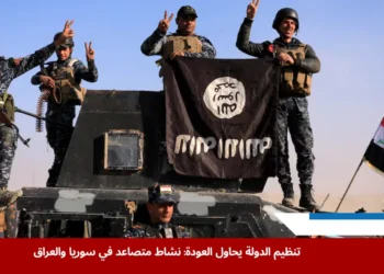 عناصر من الشرطة الاتحادية العراقية يلتقطون صورة مع راية تنظيم الدولة في أحد شوارع منطقة البو سيف جنوب الموصل بعد استعادتها من سيطرة التنظيم (رويترز)