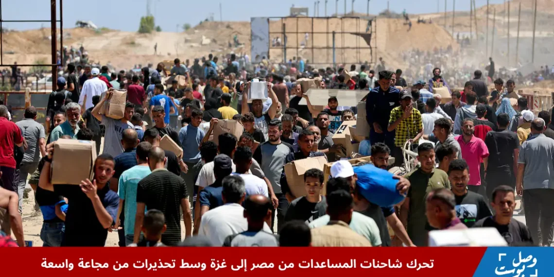 فلسطينيون ينقلون إمدادات إغاثية حصلوا عليها وسط توزيع شاحنات المساعدات من مصر في قطاع غزة المركزي ضمن جهود تخفيف الأزمة الإنسانية.