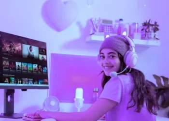 مستخدم يعمل على حاسوب محمول بنظام ويندوز 11 مع سماعات بلوتوث، يوضح ميزة تحسين جودة الصوت الجديدة