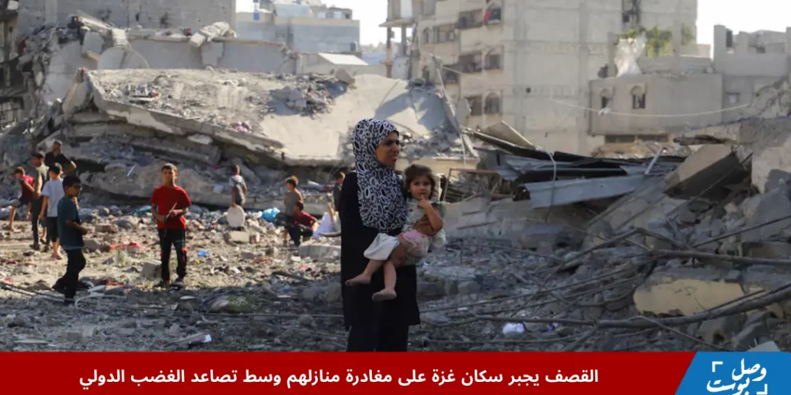 امرأة فلسطينية تحمل طفلها أثناء تفقدها موقع دمار خلفه قصف غزة الليلي على أحد المنازل