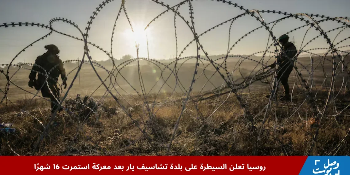 جنديان مسلحان خلف أسلاك شائكة عند شروق الشمس في منطقة شرق أوكرانيا، في مشهد يعكس أجواء التوتر بعد إعلان روسيا السيطرة على بلدة تشاسيف يار عقب معركة دامت 16 شهرًا