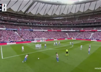 لاعب أتليتكو مدريد يستعد لتنفيذ ركلة حرة أمام دفاع ريال مدريد في ملعب واندا ميتروبوليتانو وسط حضور جماهيري كبير في الدوري الإسباني