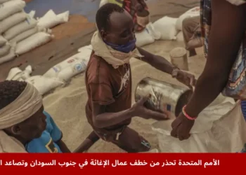 عمال يفرغون حبوب السورغم في أكياس خلال توزيع غذائي في مخيم جندراسا للاجئين بمابان، جنوب السودان، ضمن الأزمة الإنسانية الناتجة عن خطف عمال الإغاثة