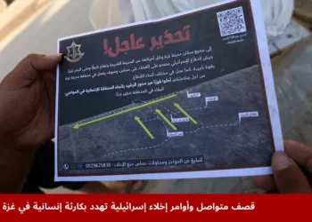 رجل فلسطيني في غزة يحمل منشورًا أسقطته القوات الإسرائيلية يتضمن أوامر إخلاء إسرائيلية تطالب سكان مدينة غزة بالمغادرة