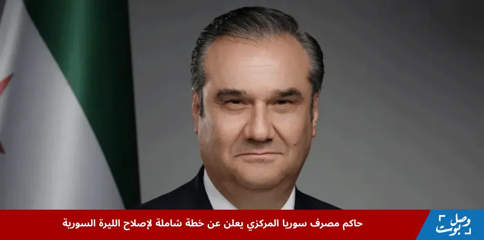 حاكم مصرف سوريا المركزي خلال إعلانه عن خطة إصلاح شاملة لليرة السورية، يظهر بجانبه علم سوريا، في سياق الإصلاح النقدي لليرة السورية.